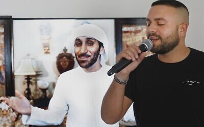 Israeli singer Elkana Marziano, 28, sings along with a video clip of a song on which he worked in collaboration with Emirati artist Walid Aljasim (image on screen), during an interview with AFP at his home in the central Israeli city of Giv'at Shmuel, on October 15, 2020. (Photo by JACK GUEZ / AFP)