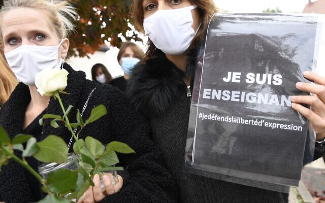 Women hold a sign reading 'I am a teacher - Freedom of speech' in front of a middle school in Conflans-Sainte-Honorine, 30kms northwest of Paris, on October 17, 2020, after a teacher was decapitated by an attacker in a terror attack. (Bertrand GUAY / AFP) Women hold a sign reading 'I am a teacher - Freedom of speech' in front of a middle school in Conflans-Sainte-Honorine, 30kms northwest of Paris, on October 17, 2020, after a teacher was decapitated by an attacker in a terror attack. (Bertrand GUAY / AFP)