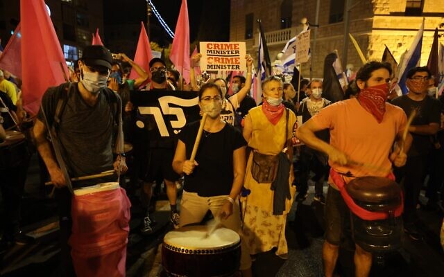 Protesters play drums during a demonstration against Prime Minister Benjamin Netanyahu near his residence in Jerusalem on October 17, 2020. (Menahem Kahana/AFP) Protesters play drums during a demonstration against Prime Minister Benjamin Netanyahu near his residence in Jerusalem on October 17, 2020. (Menahem Kahana/AFP)