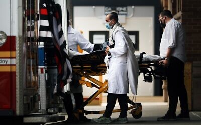New York medical workers attend to an ambulance gurney outside of Maimonides Medical Center in Borough Park where three members of the city's Orthodox Jewish communities died from the coronavirus over the last four days on September 28, 2020 in New York City. (Spencer Platt/Getty Images/AFP)