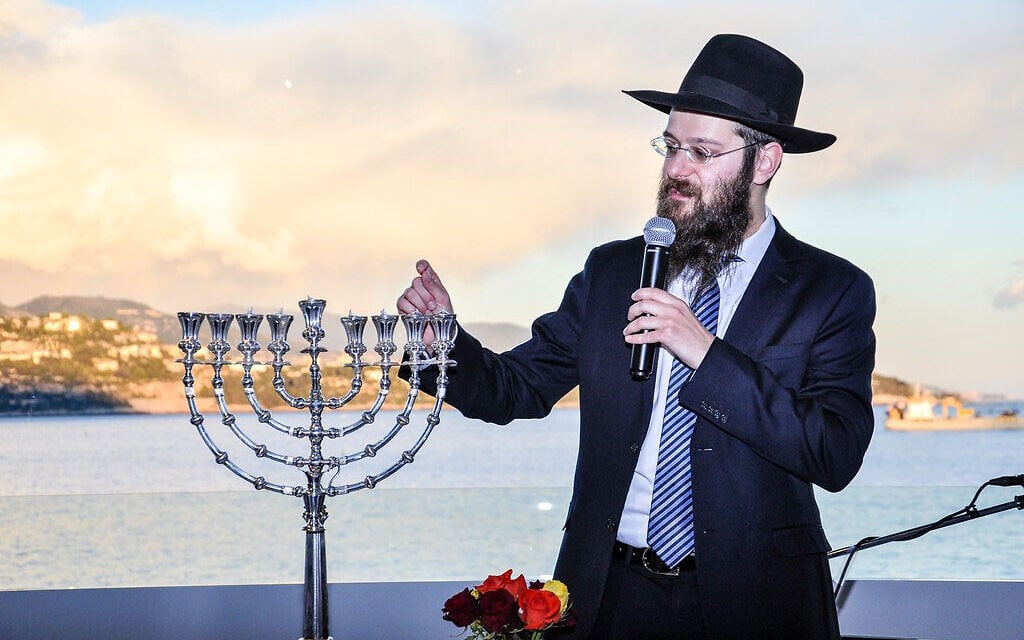 Rabbi Tanhoum Matusof lights a Hanukkah candle at a hotel in Monaco, December 25, 2016. (Courtesy of the Jewish Cultural Center of Monaco/ via JTA)