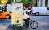 Illustrative: A Chabad emissary transports a mobile sukkah through New York City on a bicycle in 2014 (Courtesy of Chabad.org)