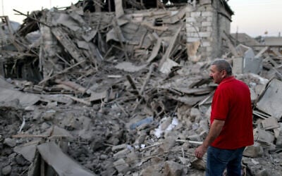 A local resident examines the ruins of a residential house destroyed in a shelling attack in the disputed Caucasus Mountains territory of Nagorno-Karabakh. (Sergei Bobylev/TASS via Getty Images)