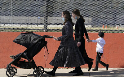 In this October 4, 2020, file photo, two women walk with children during the Jewish holiday of Sukkot in the Borough Park neighborhood of the Brooklyn borough of New York. (AP/Kathy Willens)