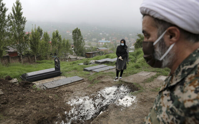A woman wearing mask and gloves, prays at the grave of her mother who died from the coronavirus, at a cemetery in the outskirts of the city of Babol, in northern Iran, April 30, 2020. (AP Photo/Ebrahim Noroozi, File) A woman wearing mask and gloves, prays at the grave of her mother who died from the coronavirus, at a cemetery in the outskirts of the city of Babol, in northern Iran, April 30, 2020. (AP Photo/Ebrahim Noroozi, File)