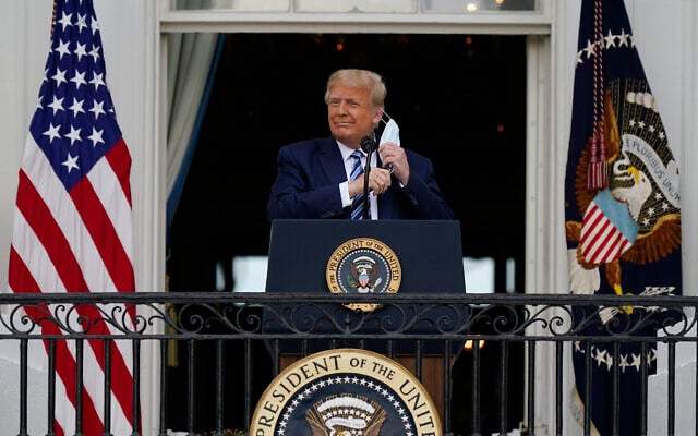 US President Donald Trump removes his face mask to speak from the Blue Room Balcony of the White House to a crowd of supporters, October 10, 2020, in Washington. (AP Photo/Alex Brandon) US President Donald Trump removes his face mask to speak from the Blue Room Balcony of the White House to a crowd of supporters, October 10, 2020, in Washington. (AP Photo/Alex Brandon)