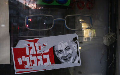 A poster reads "closed because of me" with an image of Prime Minister Benjamin Netanyahu on a closed shop in Tel Aviv, October 13, 2020. (AP Photo/Ariel Schalit)