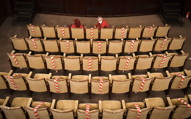 Spectators, wearing face masks for protection against COVID-19 infection, take their seats at the Jewish State Theater before the premiere of the "The Beautiful Days of My Youth" play, based on the diary of Romanian Jewish Holocaust survivor Ana Novac, which records the writer's experiences Auschwitz and Plaszow concentration camps, in Bucharest, Romania, October 16, 2020. (AP Photo/Andreea Alexandru)