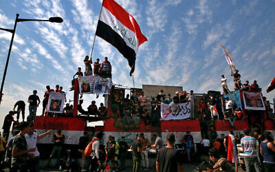 Anti-government protesters gather on the closed Joumhouriya Bridge that leads to the Green Zone government areas in Baghdad, Iraq, October 25, 2020. (AP Photo/Khalid Mohammed)