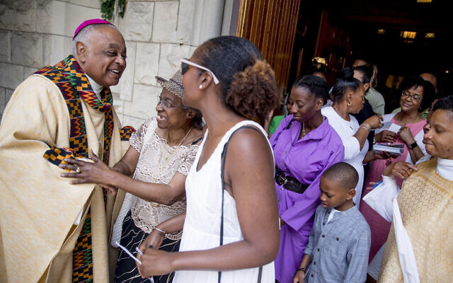 In this Sunday, June 2, 2019, file photo, Washington DC Archbishop Wilton Gregory, left, greets parishioners following Mass at St. Augustine Church in Washington. Pope Francis has named 13 new cardinals, including Washington DC Archbishop Wilton Gregory, who would become the first Black US prelate to earn the coveted red cap. (AP Photo/Andrew Harnik) In this Sunday, June 2, 2019, file photo, Washington DC Archbishop Wilton Gregory, left, greets parishioners following Mass at St. Augustine Church in Washington. Pope Francis has named 13 new cardinals, including Washington DC Archbishop Wilton Gregory, who would become the first Black US prelate to earn the coveted red cap. (AP Photo/Andrew Harnik)