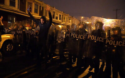 Sharif Proctor lifts his hands up in front of a police line during a protest in response to the police shooting of Walter Wallace Jr., Oct. 26, 2020, in Philadelphia (Jessica Griffin/The Philadelphia Inquirer via AP)