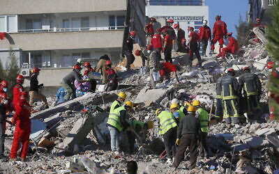 Members of rescue services search for survivors in the debris of a collapsed building in Izmir, Turkey, October 31, 2020. (AP Photo/Darko Bandic)