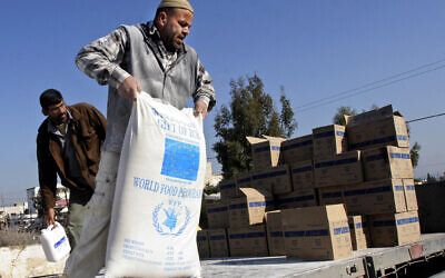 A Palestinian worker unloads foodstuffs donated by the European Union through the World Food Program and distributed by the United Nations Relief and Works Agency (UNRWA) in the West Bank village of Arrabeh near Jenin, Dec. 26, 2007. (AP Photo/Mohammed Ballas)