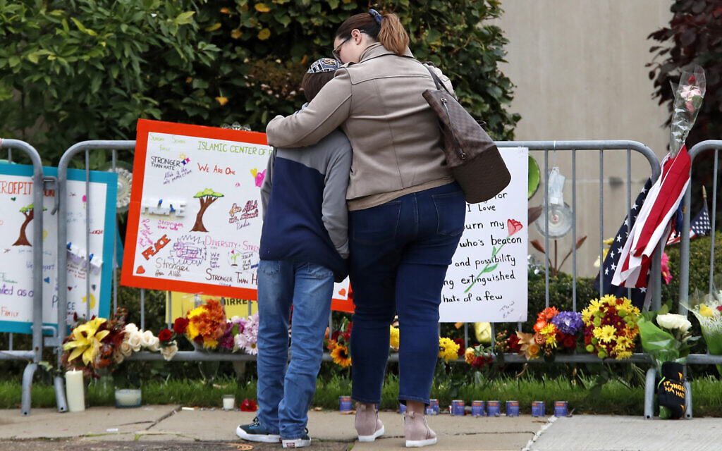 A mother hugs her son in front of a memorial at the Tree of Life synagogue in Pittsburgh on October 27, 2019. (AP/Gene J. Puskar) A mother hugs her son in front of a memorial at the Tree of Life synagogue in Pittsburgh on October 27, 2019. (AP/Gene J. Puskar)