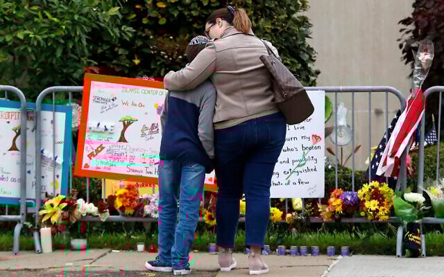 A mother hugs her son in front of a memorial at the Tree of Life synagogue in Pittsburgh on October 27, 2019. (AP/Gene J. Puskar) A mother hugs her son in front of a memorial at the Tree of Life synagogue in Pittsburgh on October 27, 2019. (AP/Gene J. Puskar)