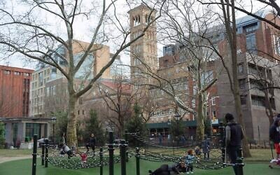 Family members play in Washington Square Park in front of New York University on March 11, 2020, in New York. (AP Photo/Kevin Hagen)