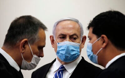 Prime Minister Benjamin Netanyahu, with his lawyers in the courtroom, as his corruption trial opens at the Jerusalem District Court, May 24, 2020. (Ronen Zvulun/ Pool Photo via AP)