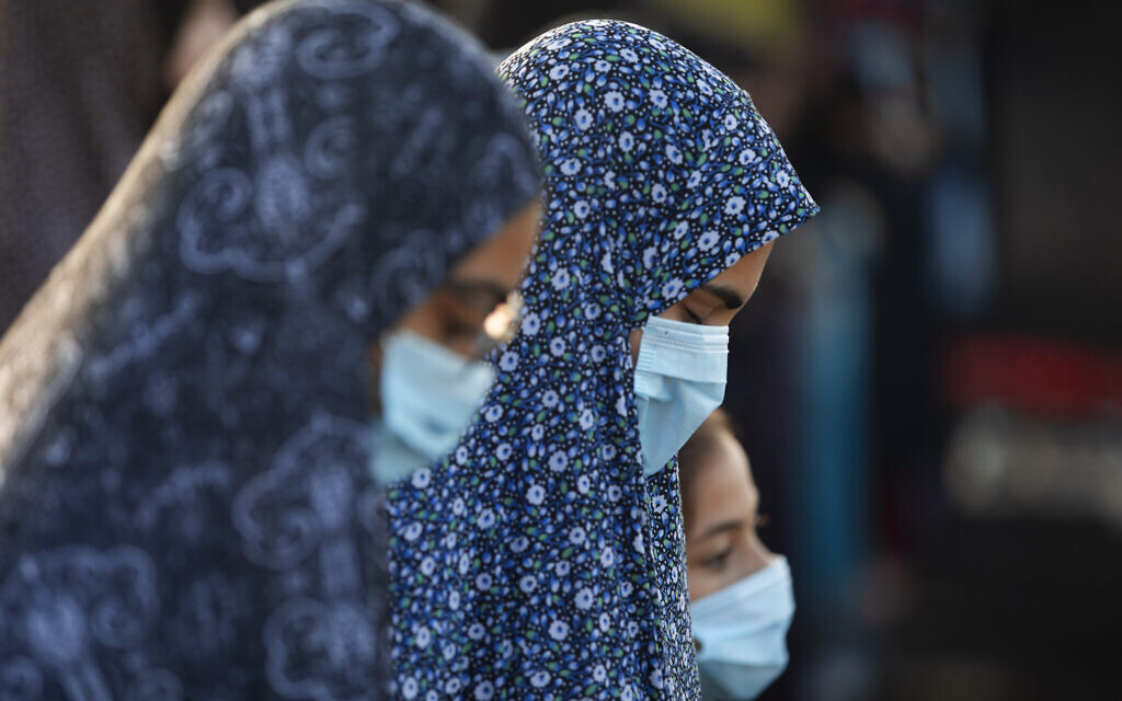 Muslim worshippers wearing face masks offer Eid al-Adha prayer at a park as mosques are limited for ten people following the government's measures to help stop the spread of the coronavirus, in the mixed Arab Jewish city of Jaffa, near Tel Aviv, Israel, Friday, July 31, 2020. (AP Photo/Oded Balilty)
