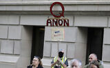 A person carries a sign supporting QAnon at a protest rally in Olympia, Washington, May 14, 2020. (Ted S. Warren/AP)