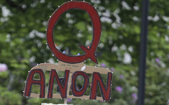 A person carries a sign supporting QAnon at a protest rally in Olympia, Washington, May 14, 2020. (Ted S. Warren/AP) A person carries a sign supporting QAnon at a protest rally in Olympia, Washington, May 14, 2020. (Ted S. Warren/AP)