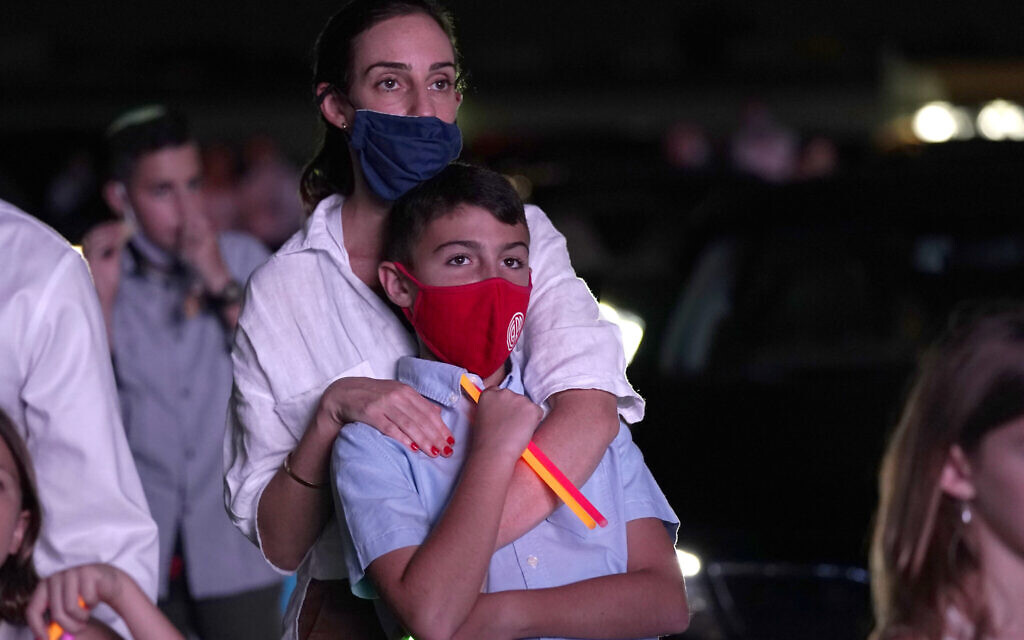 Illustrative: A woman stands with her son during a Yom Kippur service hosted by the Aventura Turnberry Jewish Center, during the coronavirus pandemic, Monday, Sept. 28, 2020, at the Dezerland Park drive-in theatre in North Miami, Fla. (AP Photo/Lynne Sladky) Illustrative: A woman stands with her son during a Yom Kippur service hosted by the Aventura Turnberry Jewish Center, during the coronavirus pandemic, Monday, Sept. 28, 2020, at the Dezerland Park drive-in theatre in North Miami, Fla. (AP Photo/Lynne Sladky)