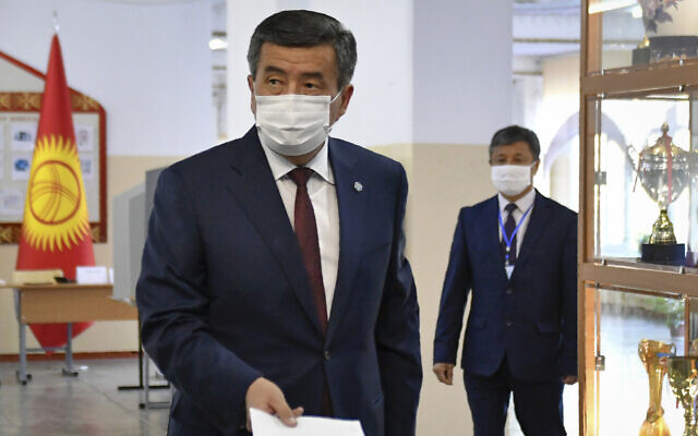 Kyrgyzstan's President Sooronbai Jeenbekov wearing a face mask casts his ballot paper during parliamentary elections in Bishkek, Kyrgyzstan, Oct. 4, 2020. (AP Photo/Vladimir Voronin) Kyrgyzstan's President Sooronbai Jeenbekov wearing a face mask casts his ballot paper during parliamentary elections in Bishkek, Kyrgyzstan, Oct. 4, 2020. (AP Photo/Vladimir Voronin)