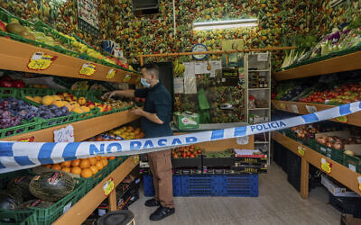 A no trespassing sign is used to keep social distance guidelines at a vegetable shop in Madrid, Spain, Oct. 6, 2020 (AP Photo/Bernat Armangue)