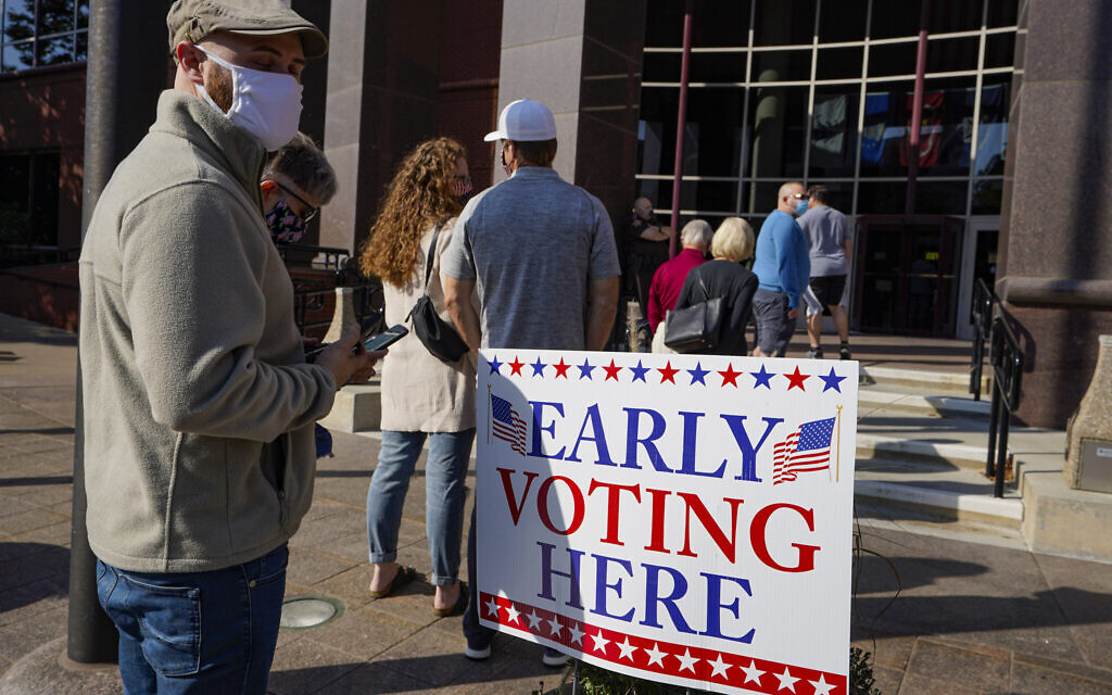 Voters wait in line at the Judicial Center in Noblesville, Indiana, Octobe 7, 2020, to cast their ballot on the second day of the state's early voting. (AP Photo/Michael Conroy)