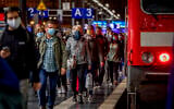 Passengers wear face masks as they leave a train in the central train station in Frankfurt, Germany, October 8, 2020. (AP Photo/Michael Probst)