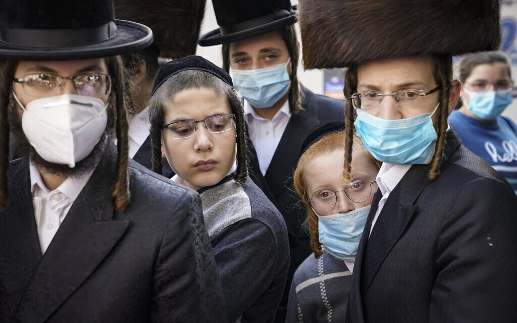 Illustrative: Members of the Jewish Orthodox community gather around a journalist as he conducts an interview on a street corner, October 7, 2020, in the Borough Park neighborhood of the Brooklyn borough of New York. (AP Photo/John Minchillo) Illustrative: Members of the Jewish Orthodox community gather around a journalist as he conducts an interview on a street corner, October 7, 2020, in the Borough Park neighborhood of the Brooklyn borough of New York. (AP Photo/John Minchillo)