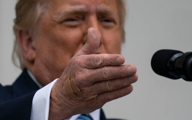 With two bandages on his hand, President Donald Trump gestures while speaking from the Blue Room Balcony of the White House to a crowd of supporters, Saturday, Oct. 10, 2020, in Washington. (AP/Alex Brandon) With two bandages on his hand, President Donald Trump gestures while speaking from the Blue Room Balcony of the White House to a crowd of supporters, Saturday, Oct. 10, 2020, in Washington. (AP/Alex Brandon)