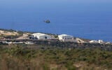 A helicopter flies over a base of the UN peacekeeping force, in the town of Naqoura, Lebanon, October 14, 2020, during the first round of talks between Lebanese and Israeli delegations on the countries' maritime border. (AP/Bilal Hussein)