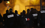 French police officers gather outside a high school after a history teacher who opened a discussion with students on caricatures of Islam's Prophet Muhammad was beheaded in Conflans-Saint-Honorine, north of Paris, October 16, 2020. (AP Photo/Michel Euler)
