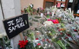 A poster reading "I am Samuel" and flowers outside the school where slain history teacher Samuel Paty worked, on October 17, 2020, in Conflans-Sainte-Honorine, northwest of Paris. (AP/Michel Euler)