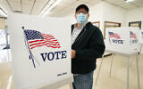 A man fills out his ballot during early voting for the US presidential election, October 20, 2020, in Adel, Iowa. (AP Photo/Charlie Neibergall)