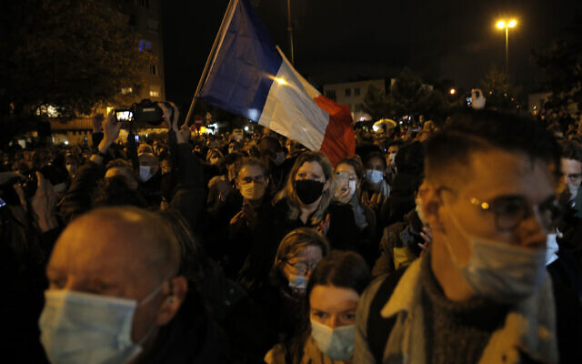 People attend a memorial march in homage to the history teacher who was beheaded last week, Tuesday, Oct.20, 2020 in Conflans-Sainte-Honorine, northwest of Paris. Samuel Paty was beheaded on Friday by an 18-year-old Moscow-born Chechen refugee, who was later shot dead by police. Police officials said Paty had discussed caricatures of Islam's Prophet Muhammad with his class, leading to threats. (AP Photo/Lewis Joly) People attend a memorial march in homage to the history teacher who was beheaded last week, Tuesday, Oct.20, 2020 in Conflans-Sainte-Honorine, northwest of Paris. Samuel Paty was beheaded on Friday by an 18-year-old Moscow-born Chechen refugee, who was later shot dead by police. Police officials said Paty had discussed caricatures of Islam's Prophet Muhammad with his class, leading to threats. (AP Photo/Lewis Joly)