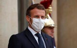 French President Emmanuel Macron, left, wearing a protective face mask, waits to welcome Armenian President Armen Sarkissian for a meeting at the Elysee Palace in Paris, Thursday, Oct. 22, 2020. (Charles Platiau/Pool via AP)