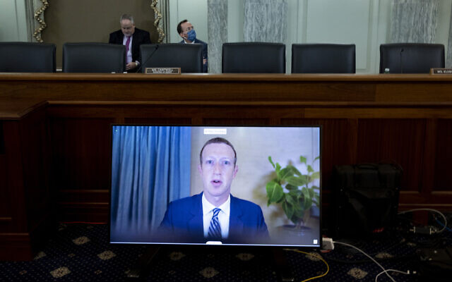Facebook CEO Mark Zuckerberg appears on a screen as he speaks remotely during a hearing before the Senate Commerce Committee on Capitol Hill, October 28, 2020, in Washington (Michael Reynolds/Pool via AP) Facebook CEO Mark Zuckerberg appears on a screen as he speaks remotely during a hearing before the Senate Commerce Committee on Capitol Hill, October 28, 2020, in Washington (Michael Reynolds/Pool via AP)