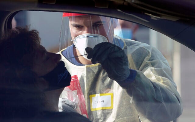 Cody Tupen, a firefighter with the Puget Sound Regional Fire Authority, performs a deep nasal nose-swab COVID-19 test on Nancy Backus, left, the mayor of Auburn, Washington, at a King County COVID-19 testing site in Auburn, south of Seattle, October 28, 2020. (AP Photo/Ted S. Warren) Cody Tupen, a firefighter with the Puget Sound Regional Fire Authority, performs a deep nasal nose-swab COVID-19 test on Nancy Backus, left, the mayor of Auburn, Washington, at a King County COVID-19 testing site in Auburn, south of Seattle, October 28, 2020. (AP Photo/Ted S. Warren)