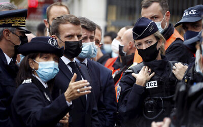 French President Emmanuel Macron, second left, and Nice mayor Christian Estrosi , third left, meet police officers after a knife attack at Notre Dame church in Nice, southern France, October 29, 2020. (Eric Gaillard/Pool via AP)