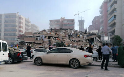 People work on a collapsed building, in Izmir, Turkey, Oct. 30, 2020, after a strong earthquake in the Aegean Sea has shaken Turkey and Greece (DHA via AP)