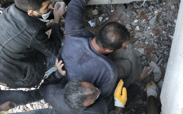 Rescue workers and local people try to reach residents trapped in the debris of a collapsed building, in Izmir, Turkey, Friday, Oct. 30, 2020, after a strong earthquake in the Aegean Sea has shaken Turkey and Greece. T(AP Photo/Ismail Gokmen)