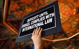 Illustrative: A man holds a sign during a rally in the War Room at the state Capitol on June 15, 2016, in Albany, New York (AP Photo/Mike Groll)