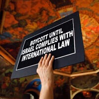 Illustrative: A man holds a sign during a rally in the War Room at the state Capitol on June 15, 2016, in Albany, New York (AP Photo/Mike Groll)