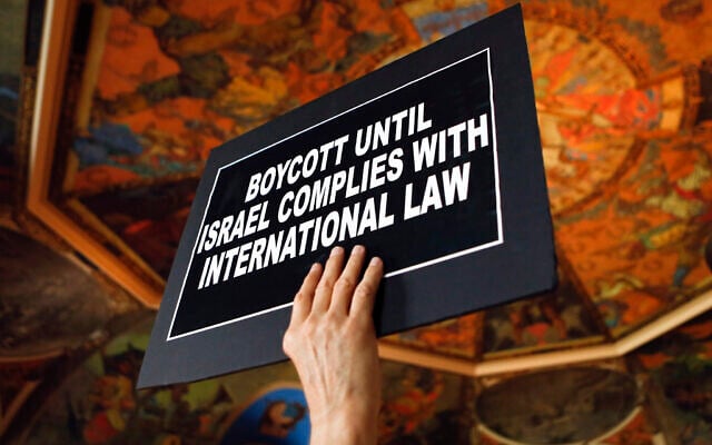 Illustrative: A man holds a sign during a rally in the War Room at the state Capitol on June 15, 2016, in Albany, New York (AP Photo/Mike Groll)