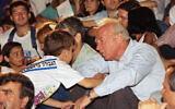 A child shakes the hand of Yitzhak Rabin, head of the Labor party, at an election rally held June 20, 1992 in Tel Aviv, days before Rabin's election victory. (AP Photo/Nati Harnik)