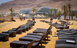 Empty sun loungers on a beach near the Dead Sea hotel complex, on July 10, 2019. (Gershon Elinson/Flash90)