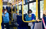 Commuters wear face masks as they ride a public bus in the southern city of Ashkelon, March 29, 2020 (Flash90)