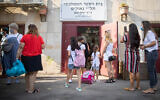 First grade students arrive for their first day of school at Tali Geulim school in Jerusalem on September 1, 2020. (Noam Revkin Fenton/Flash90)
