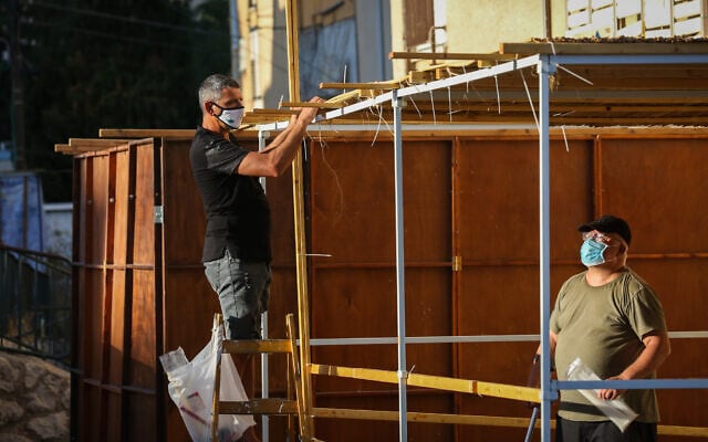 Jews build a sukka for the upcoming holiday of Sukkot, in the northern city of Safed, September 29, 2020. (David Cohen/Flash90) Jews build a sukka for the upcoming holiday of Sukkot, in the northern city of Safed, September 29, 2020. (David Cohen/Flash90)
